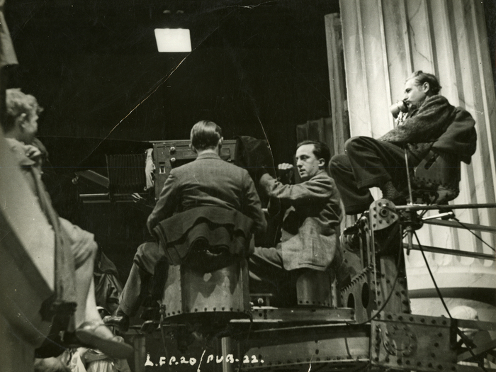 Photographie de tournage de I, Claudius : Charles Laughton (en costume à gauche), à la caméra Georges Périnal et son assistant Robert Krasker (de dos), Josef von Sternberg (à gauche).