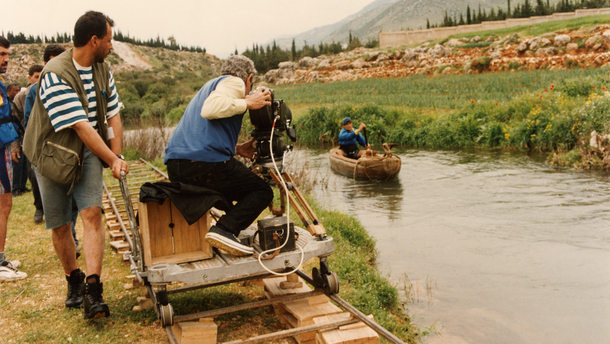 Photographie de tournage « Le Destin  »(1996) © Photo Michel Y. El Esta. Youssef Chahine à la caméra, installé sur un chariot roulant sur des rails pour effectuer un travelling.