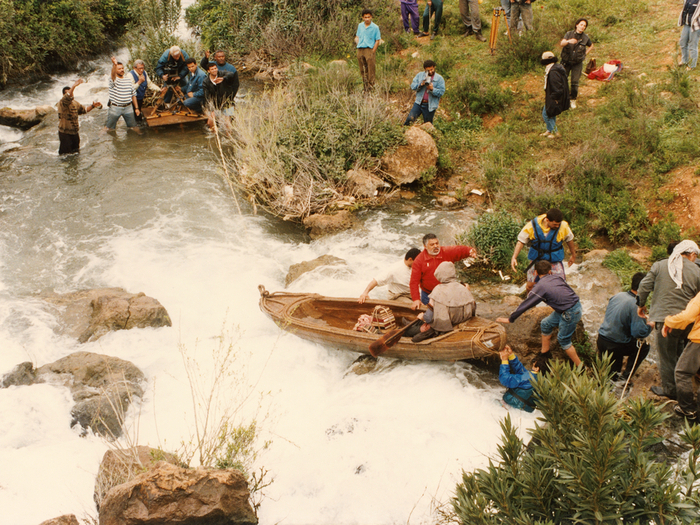 Photographie de tournage « Le Destin » (1996) © Photo Michel Y. El Esta. Youssef Chahine et son équipe technique, installés sur une barge avec la caméra, sont prêts à tourner. La barque où est assis l'acteur est encore retenue par des assistants